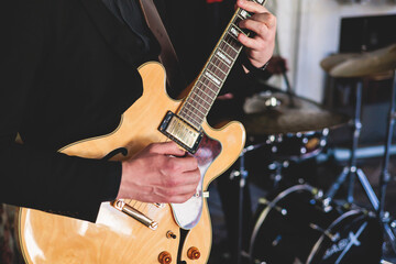 Concert view of an electric guitar player with vocalist and musical jazz band orchestra performing...