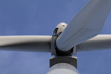 Nahaufnahme der Nabe einer Windkraftanlage vor blauem Himmel