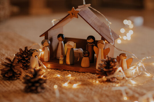 Selective focus shot of a nativity scene surrounded by Christmas lights