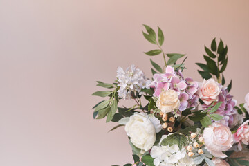 A gorgeous pastel pink bouquet of peonies in close-up on a sand-colored background. Flowers in interior design. Cozy house. High quality photo