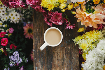 Good fall morning. Warm cup of coffee and beautiful autumn flowers on rustic wooden background flat...
