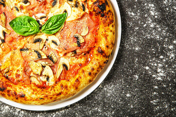 Hot tasty traditional pizza with ham and mushrooms.