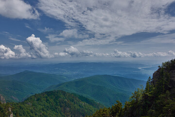 View over the mountains seen from a rocky mountainside with an overcast sky