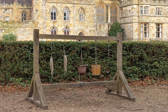Wooden rack with backets and pots and pans hanging on chains
