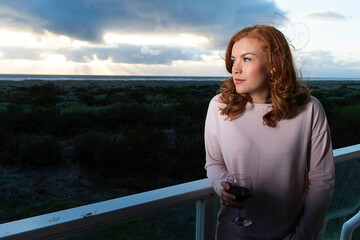 Pretty woman with red hair and freckles at the ocean beach