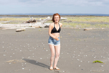 Woman with red hair at sandy ocean beach outside