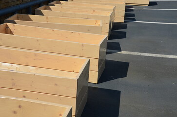 funeral services have many contracts. production of cheap coffins or wooden flower pots for the terrace feeds carpenters. row of empty wooden rectangular flower boxes