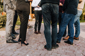 Legs of people, men, women close-up outdoors. Business, meeting and meeting of businessmen about work. Holiday, corporate party of friends.