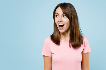 Young surprised amazed happy woman 20s wearing pink t-shirt look aside on workspace area mock up...