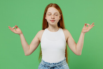 Little redhead kid spiritual girl 12-13 years old in white tank shirt hold spreading hands in yoga...