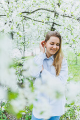 Portrait of beautiful romantic lady in apple trees blossoms