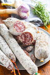 Traditional sausage with white mold. Dried pork salami on plate.