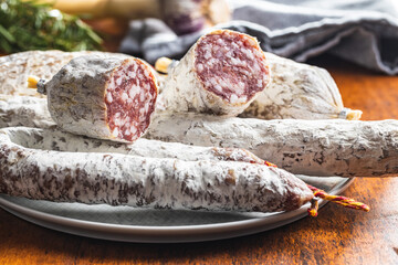 Traditional sausage with white mold. Dried pork salami on plate.