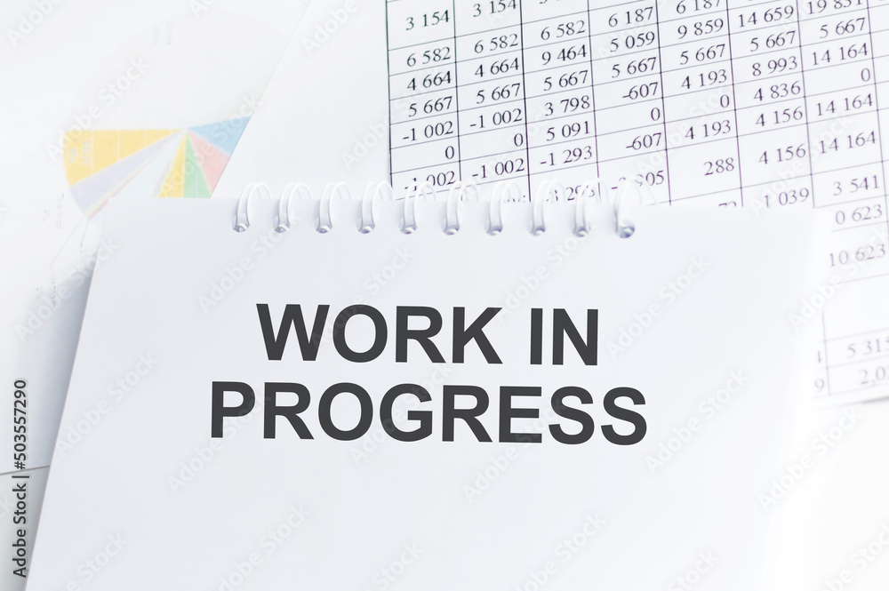 Poster working in progress text on a notepad on an office desk, a business concept