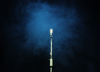 Microphone in a smoke on a dark background
