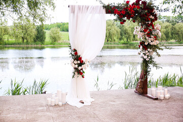  beautiful wedding arch decorated with flowers arch on the background of the lake
