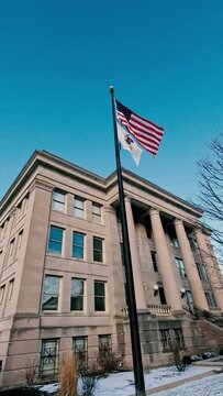 American flag and Illinois state flag wave in front of the Fourth District Appellate Courthouse.