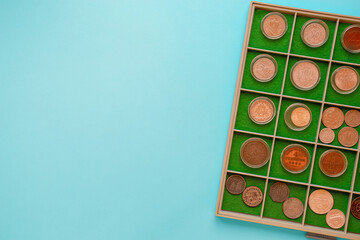 Numismatics coin collection album with copy space. Top view of old rare coins on blue background