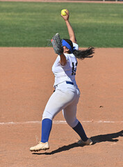 Athletic girls in action playing in a softball game
