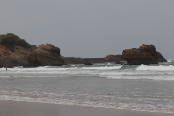 Biarritz coast beach with lighthouse and surfers