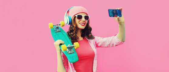Summer colorful portrait of stylish modern young woman taking a selfie by smartphone with...