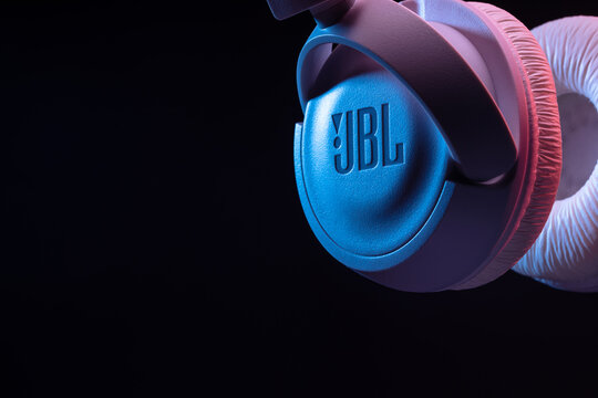 USINSK, RUSSIA - MAY 5, 2022: Close-up of JBL Wireless Bluetooth headphones on a black background with neon backlight