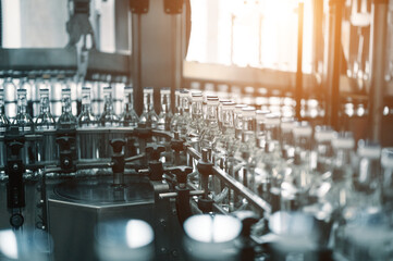 Closed glass bottles of upscale vodka transported by line