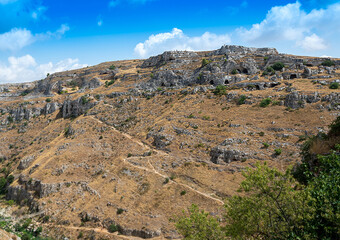 Landscape of the hills of Matera where we can recognize the oldest cave houses inhabited by man. Beautiful summer day.