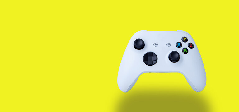 White controller of the new video game console. On yellow background