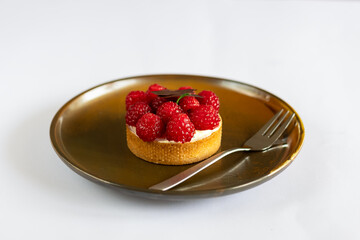 Cake with fresh berries on a plate fork. White background