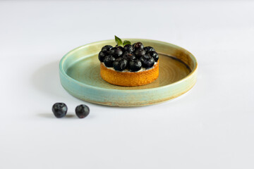 cake with fresh berries, blueberries on a plate. White background. Minimalism