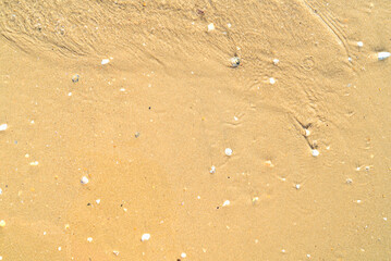Sand with stones and sea water top view background