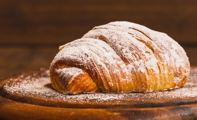 Croissant close up on wooden board table copy space background.