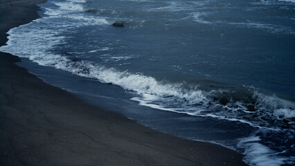 Water waves splashing coast on dark natural environment. Blue sea storm outside.