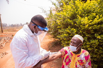 Senior african man getting vaccinated outdoor during Covid-19 pandemic era