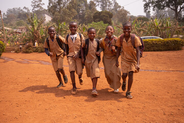 Young group of african children all together at school yard having fun playing holding hands - obrazy, fototapety, plakaty