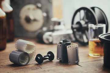 Old photo film rolls, cassette and photographic equipment on background - developing tank with its...