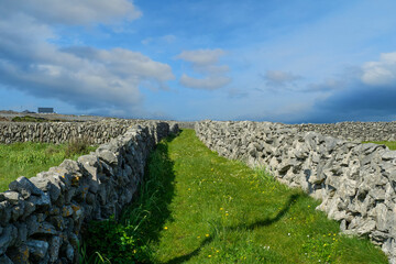 Small narrow road between stone fences. Aran island, county Galway, Ireland. Irish nature...