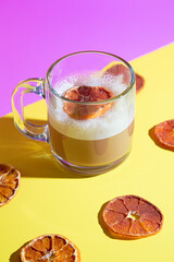 Coffee cocktail in clear mug with surrounding dehydrated orange garnishes - front angle