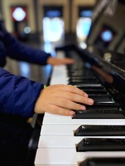 Obraz premium Manos de niño sobre las teclas de un piano