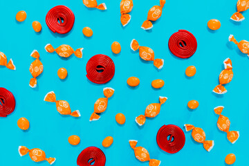 Candy, orange candies and red swirls on blue background. assortment of candies. wallpaper to use text.