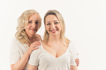 2 beautiful blonde women. Shot of a attractive mom and her young daughter over white background in the studio. High quality photo