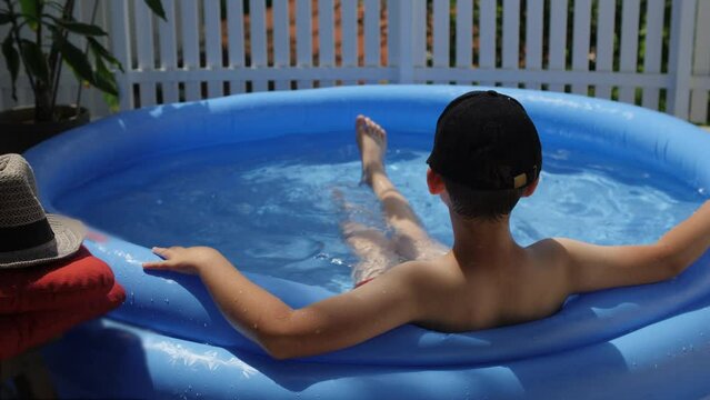 Little boy in water pool in the summer day