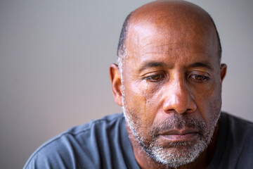Portrait of a mature man looking sad with tears in his eyes.