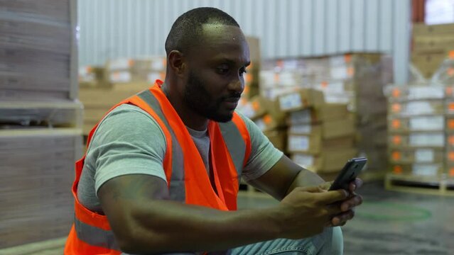 Business concept of 4k Resolution. Employees are taking a break from working in a warehouse. playing mobile phone.
