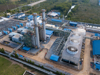 Aerial view of gas turbine power plant factory with cooling system fan in operation that producing...