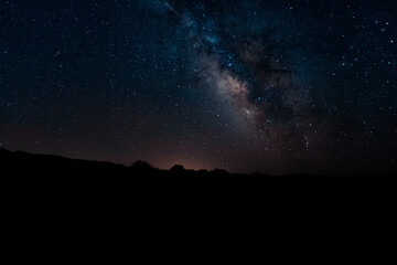 Fototapeta na wymiar The Milky Way galaxy over the landscape in silhouette