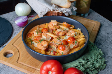 Delicious pasta pene with shrimps and tomato sauce with herbs