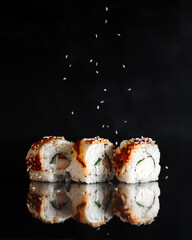 Traditional delicious fresh Unagi Syake sushi roll set on a black background with reflection. Sushi...