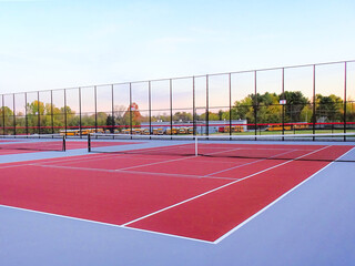 Obraz premium New red tennis courts with white lines and gray pickleball lines.